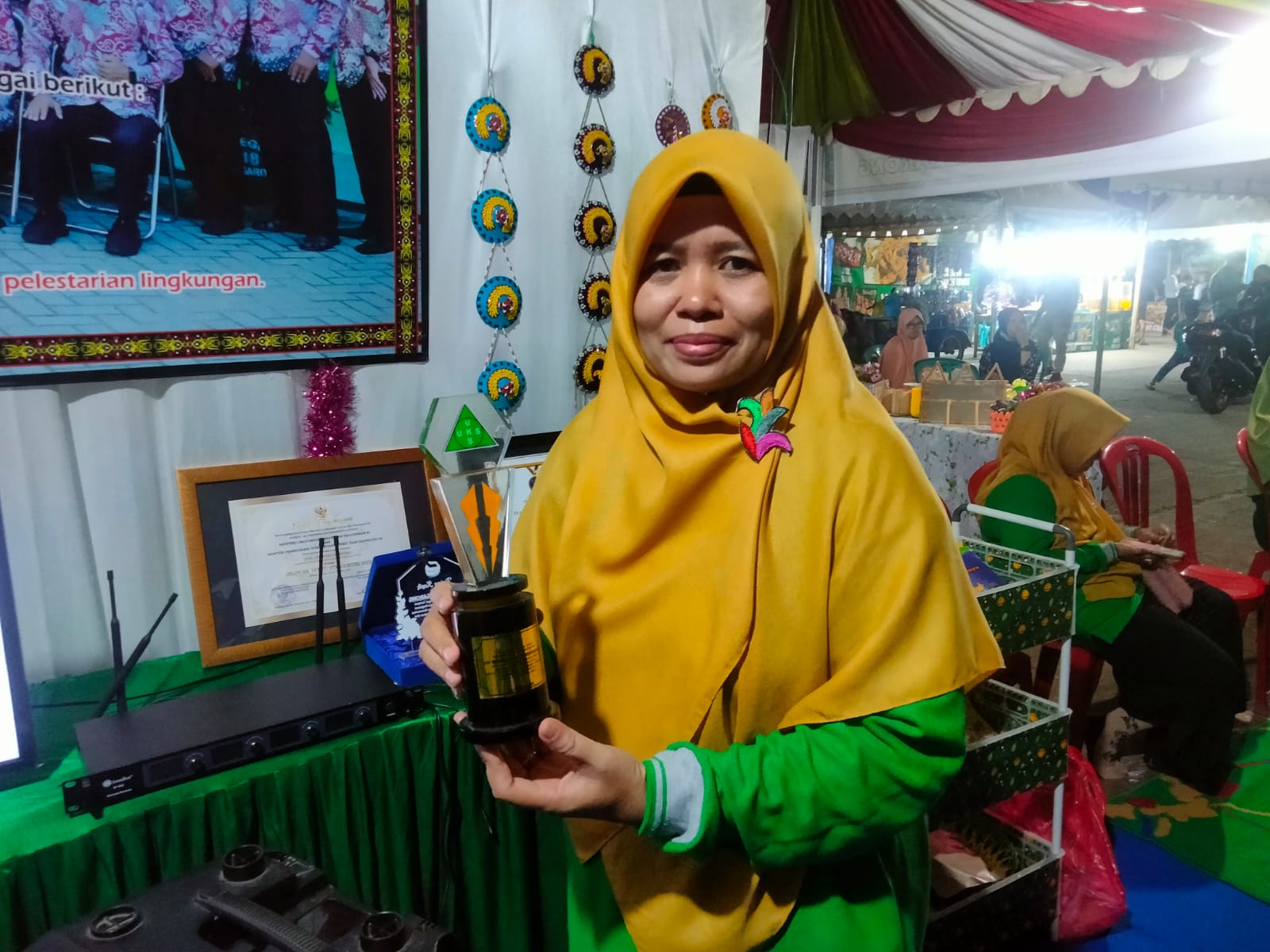 Guru SDN 018 Tenggarong, Siti Mariani saat menunjukkan piala lomba sekolah sehat tingkat provinsi Kalimantan Timur (Mahakam Daily)